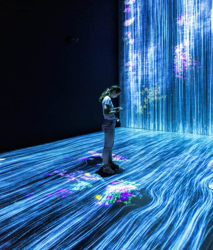 One Person with a phone on a futuristic platform representing digitization, which goes into the background.